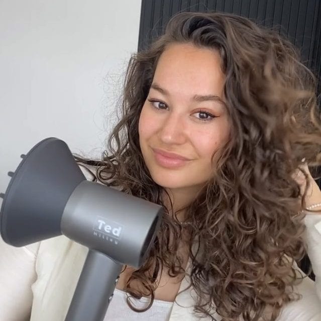 Vrouw gebruikt Ted Hilley Ionische Fohn - Beste Fohn 2025 (Krullenclub) voor glanzend, pluisvrij krullend haar
